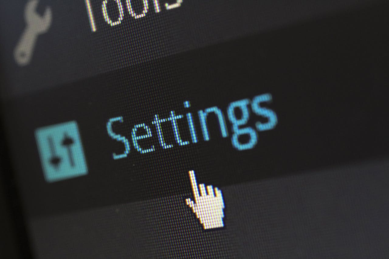 A close-up photo of a computer screen showing the settings button with a cursor hovering over it.
